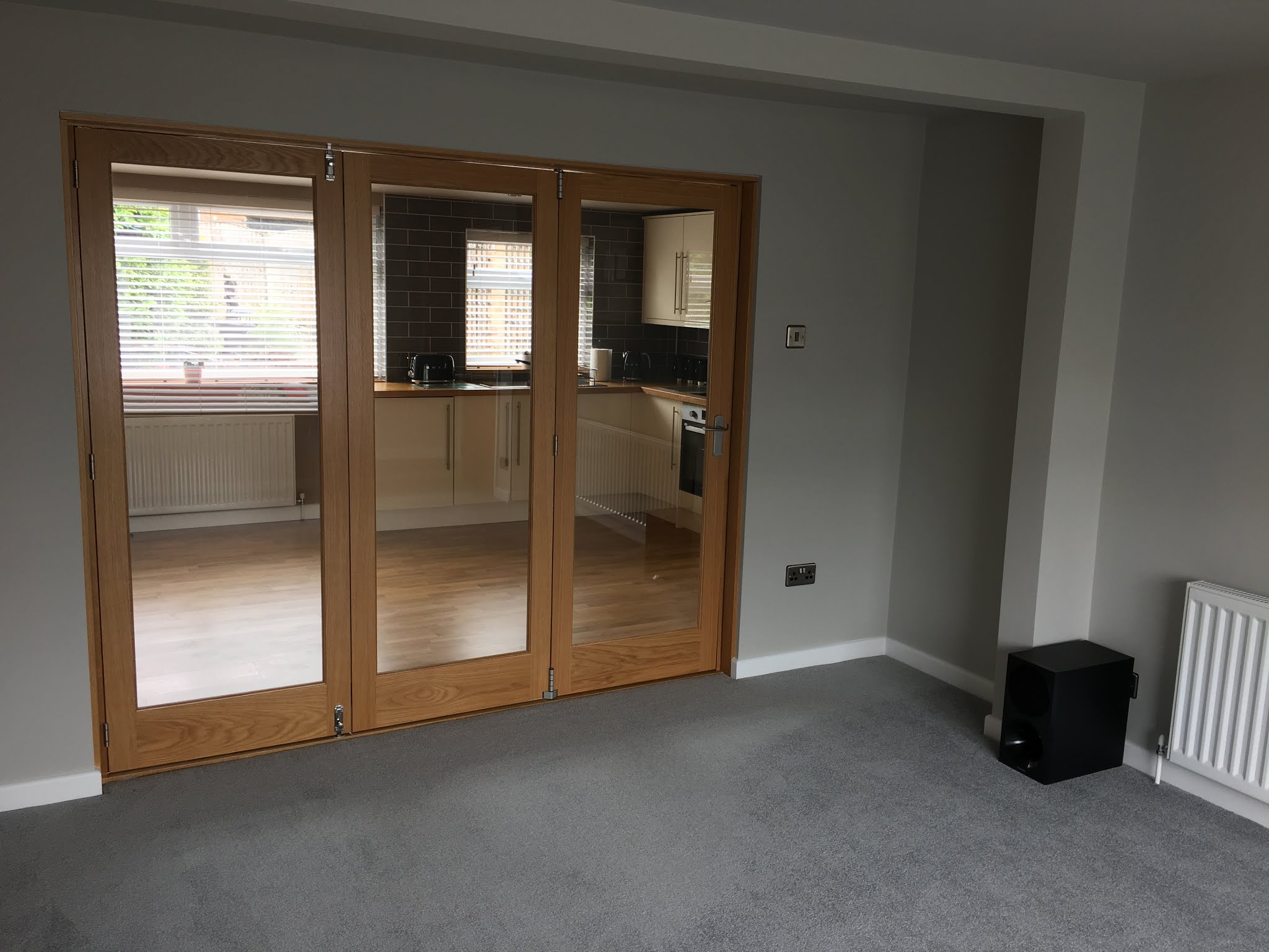 Glazed timber folding doors opening onto a kitchen