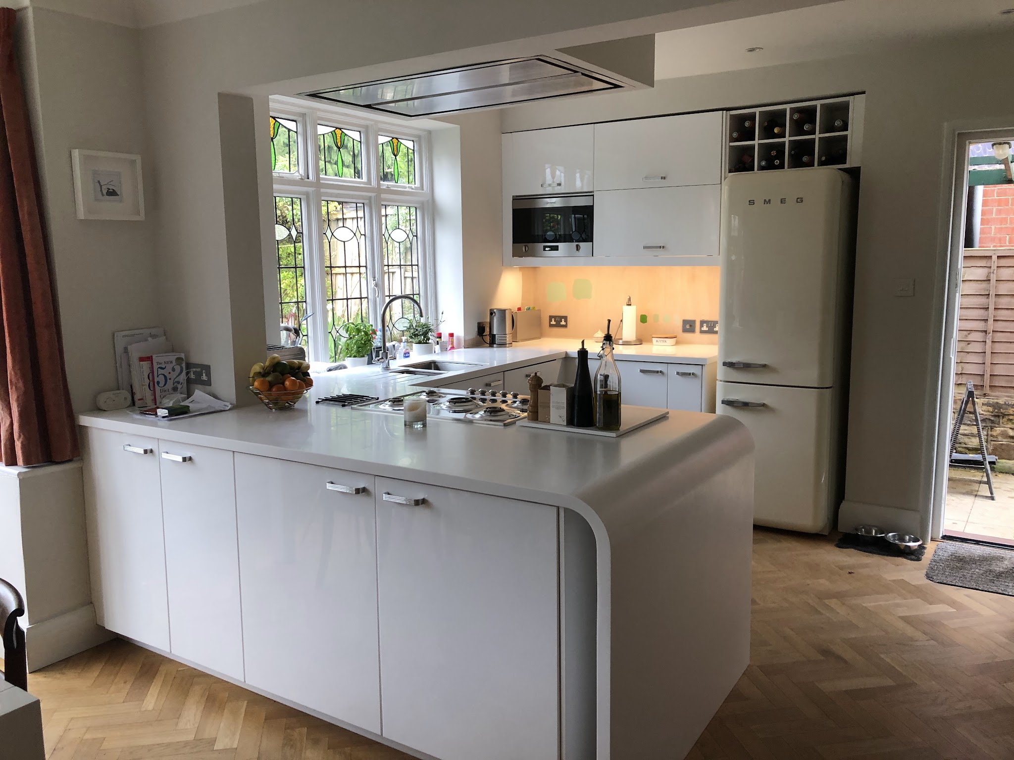 White fitted kitchen with a curved peninsula